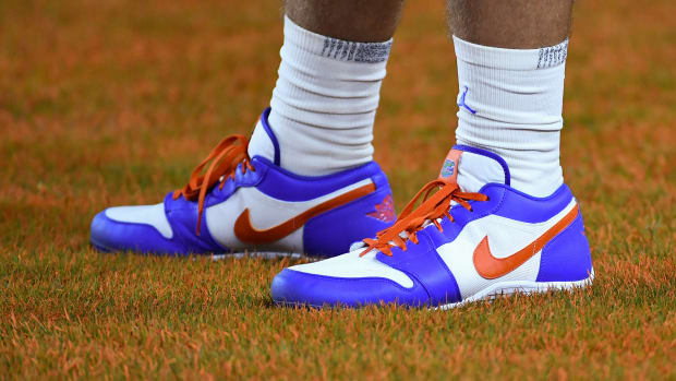 View of a Florida Gators football player's blue and orange Air Jordan cleats.